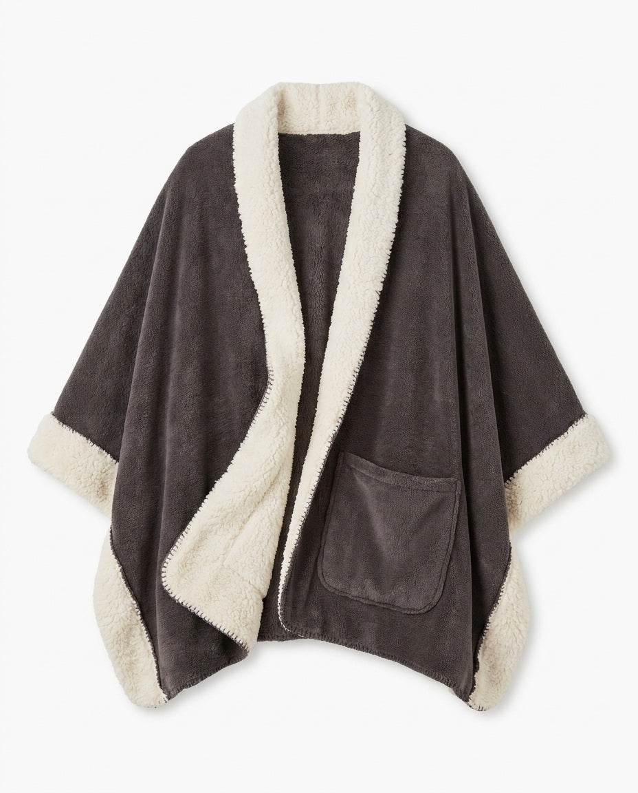 The Reader's Wrap laid flat: charcoal grey fleece front, cream sherpa lining and border, deep front patch pocket